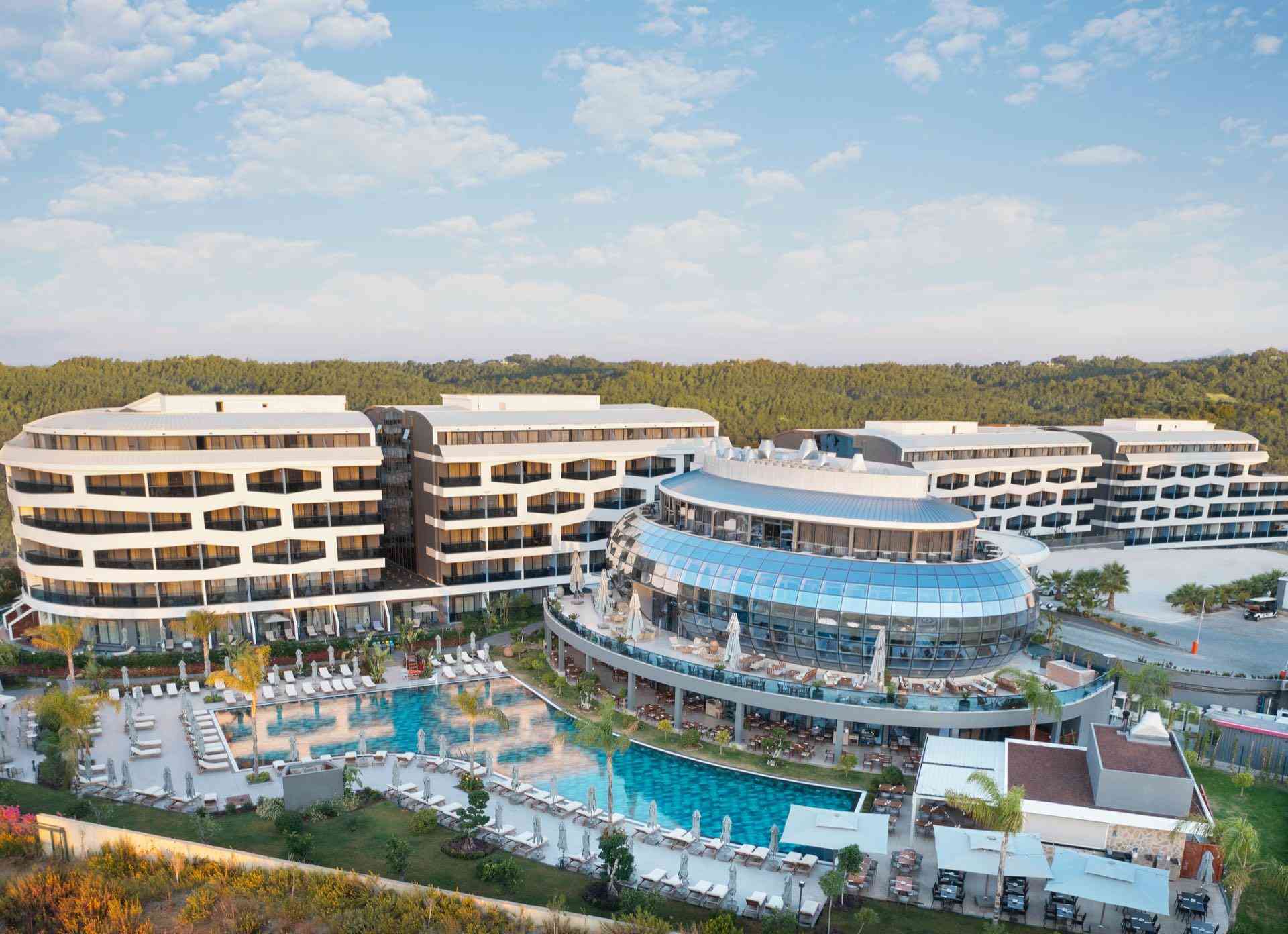 LIU Resorts · Moderner Hotelkomplex mit Pools und Terrassen unter bewölktem Himmel.