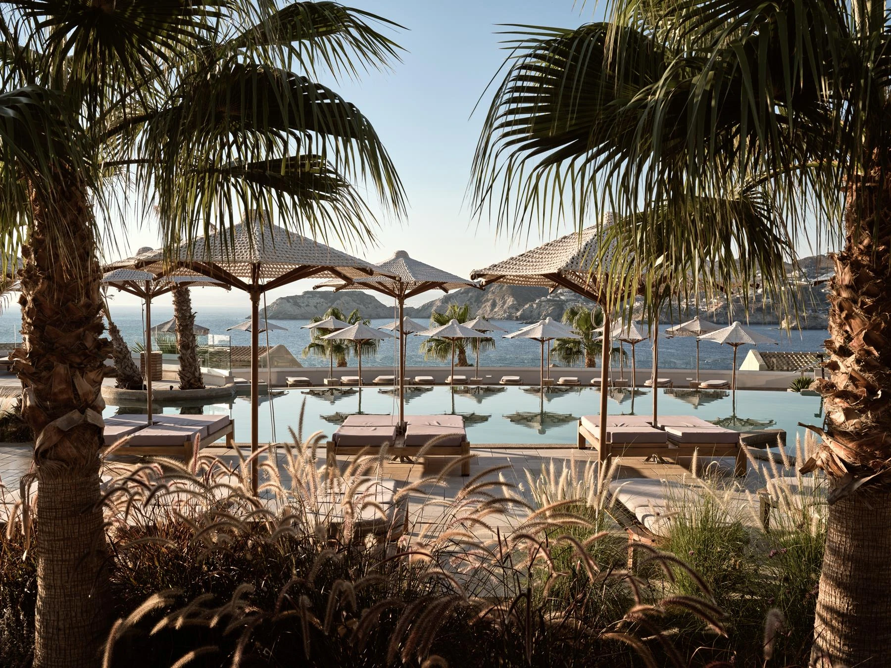 Poolterrasse mit Palmen und Blick zum Meer im Seaside